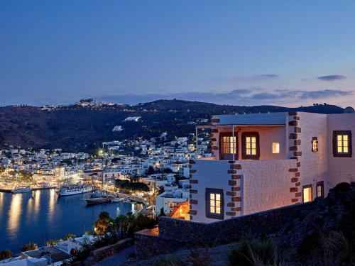 a house with a view of a harbor at night at Patmos Eye Boutique Hotel & Villas in Skala
