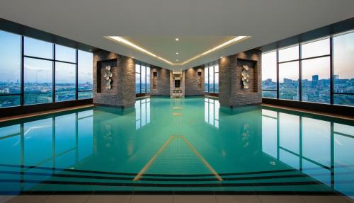 伊斯坦堡的住宿－韋斯特賽德羅塔納中心酒店，一座带窗户的建筑中的游泳池