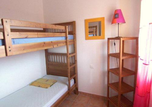 a bedroom with two bunk beds and a lamp at LAURENCE in Porto-Vecchio