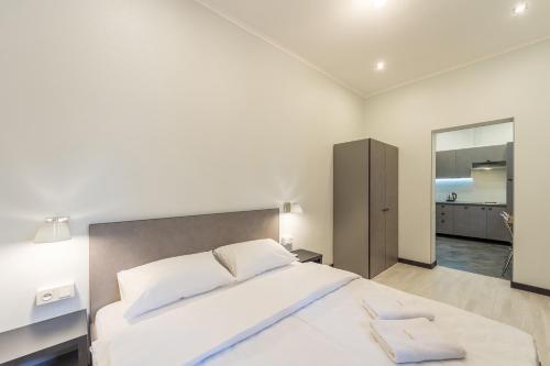 a bedroom with a large white bed and a mirror at DayFlat Apartments Golden Gate Area in Kyiv