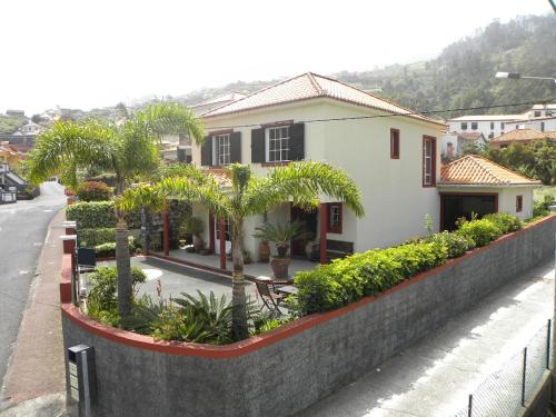 a house with trees and plants in front of a street at Moradia Ponte de Pedra in São Vicente