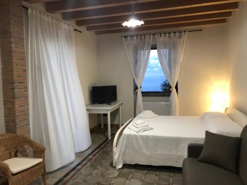 Schlafzimmer mit einem Bett und einem Fenster mit einem TV in der Unterkunft Villa Tecla in Capri Leone