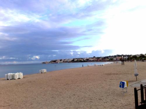 a sandy beach with chairs and the ocean at Altinersan Hotel in Didim