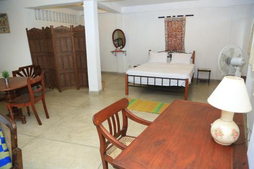 a living room with a table and a bed at Riverside Suites in Kandy
