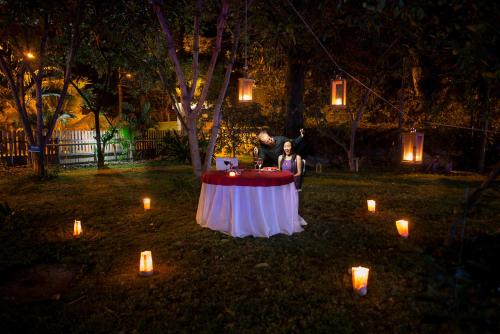 a man and a woman standing at a table with candles at Palmazul Hotel & Spa in San Clemente