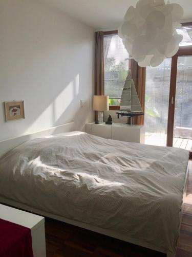 a white bed in a bedroom with a large window at Seehaus Inselwelt in Jois