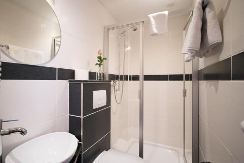 a bathroom with a shower and a toilet and a sink at Hotel-Burghagen in Langelsheim