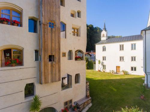 an external view of a building with flowers in the windows at Turm zu Schloss Schedling in Trostberg an der Alz