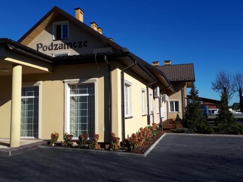 a building with a sign on the side of it at Zajazd Podzamcze in Fałków
