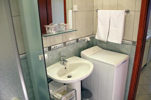 a small bathroom with a sink and a washing machine at Apartments Artemis Dubrovnik in Dubrovnik