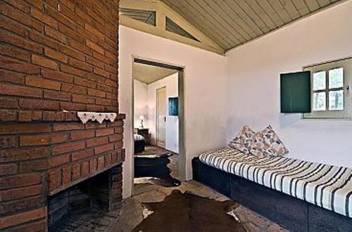 a room with a brick wall and a bed at Pousada Chácara das Roseiras in Bagé