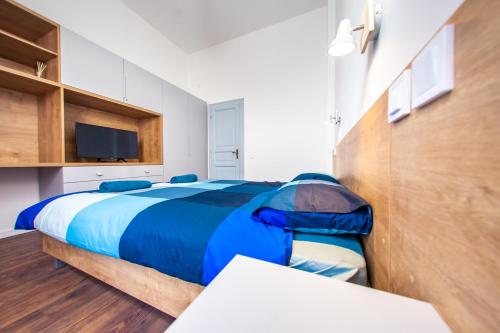 a bedroom with a blue bed and a tv at Central Luxury 1 in Cluj-Napoca