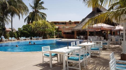 a pool with tables and chairs and people in the water at Safari Village Saly V 225 in Saly Portudal