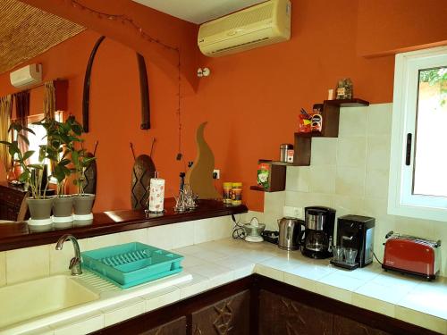 a kitchen with an orange wall and a sink at Safari Village Saly V 225 in Saly Portudal