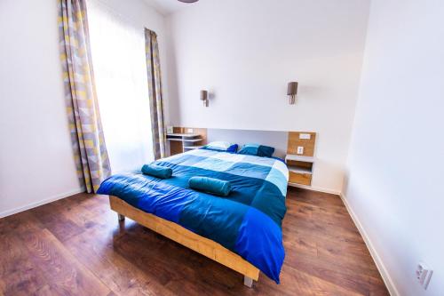 a bedroom with a bed with blue sheets and blue pillows at Central Luxury 2 in Cluj-Napoca