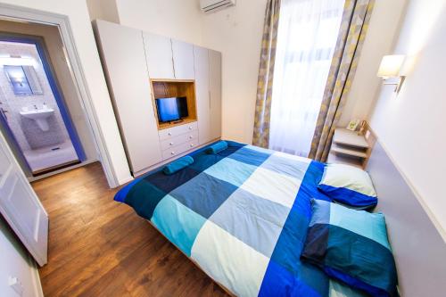 a bedroom with a blue and white bed and a bathroom at Central Luxury 2 in Cluj-Napoca