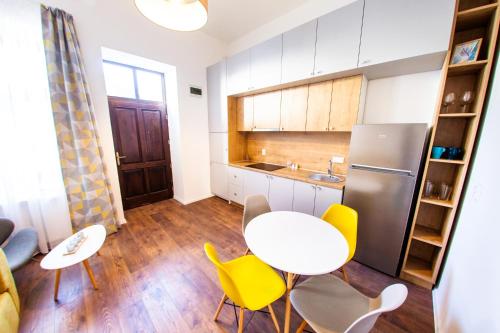 a kitchen with a table and chairs and a refrigerator at Central Luxury 2 in Cluj-Napoca
