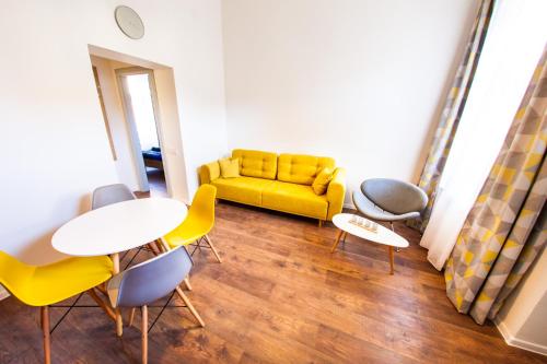 a living room with a yellow couch and chairs at Central Luxury 2 in Cluj-Napoca