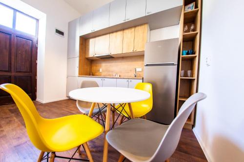 a kitchen with a table and yellow chairs at Central Luxury 2 in Cluj-Napoca