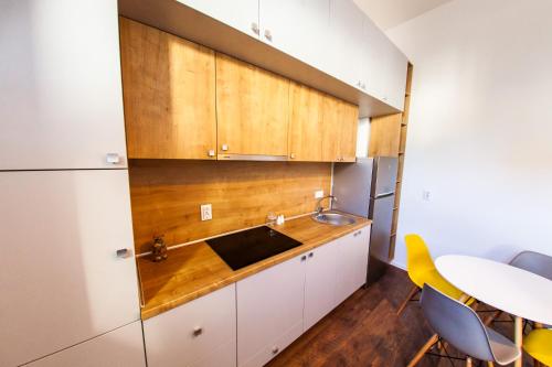 a kitchen with white cabinets and a sink and a table at Central Luxury 2 in Cluj-Napoca