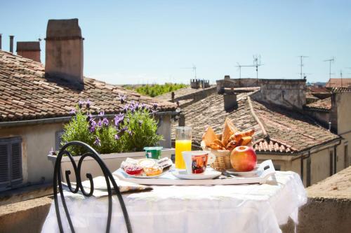 une table avec une assiette de nourriture sur un balcon dans l'établissement Kyriad Nimes Centre, à Nîmes