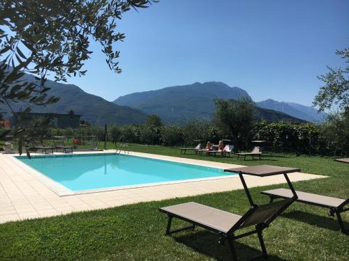 a swimming pool with two chairs and a table at Agriturismo Maso Bergot in Arco
