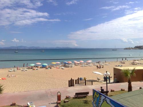 a beach with umbrellas and people on the beach at Altinersan Hotel in Didim
