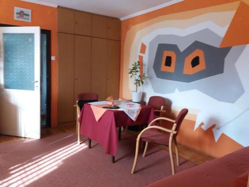 布達凱西的住宿－布達凱希公寓，一间设有桌子和墙上绘画的用餐室