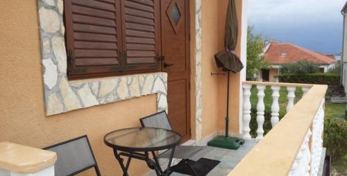 a table and a chair sitting on a balcony at Studio Apartment in Nin with Balcony, Air Conditioning, Wi-Fi (3718-2) in Nin