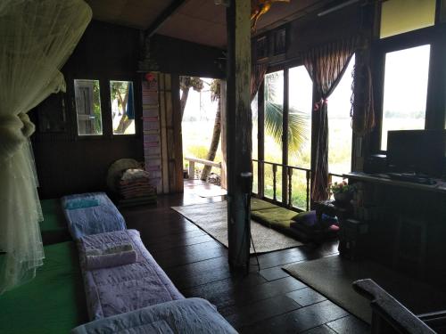 een kamer met banken en een kamer met ramen bij Oui Kaew Homestay in Phayao