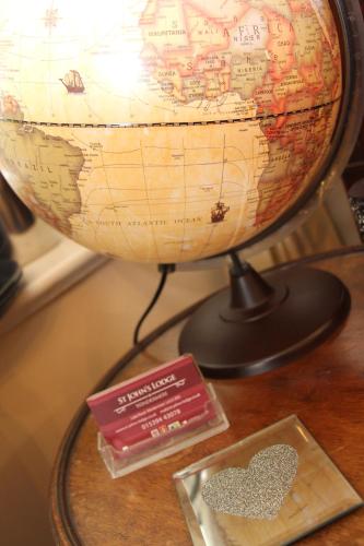 a globe on a table with a book and a heart at St John's Lodge incl off-site leisure club in Windermere