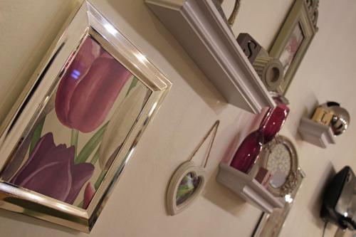 a mirror on a wall with a picture of a flower at St John's Lodge incl off-site leisure club in Windermere