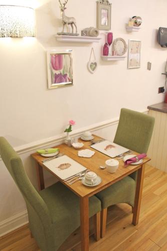 a dining room table with two chairs and a wooden table at St John's Lodge incl off-site leisure club in Windermere