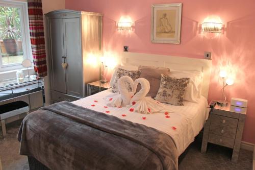 a bedroom with a large bed with two swans on it at St John's Lodge incl off-site leisure club in Windermere