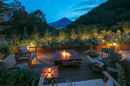 a patio with a table and a fire pit at night at Fufu Kawaguchiko in Fujikawaguchiko