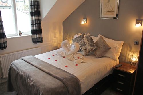 a bedroom with a bed with two swans on it at St John's Lodge incl off-site leisure club in Windermere