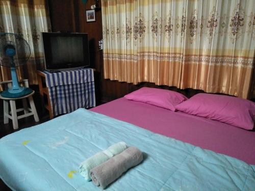 a bedroom with a bed with two towels on it at Oui Kaew Homestay in Phayao