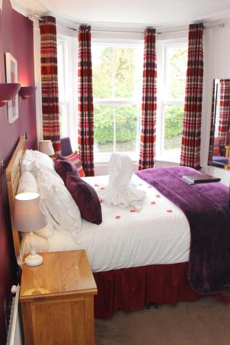 a bedroom with a large bed with a window at St John's Lodge incl off-site leisure club in Windermere