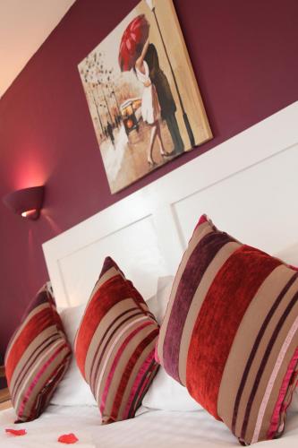 a bed with two red and white pillows on it at St John's Lodge incl off-site leisure club in Windermere