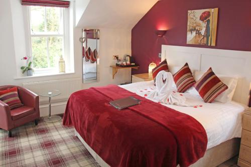 a bedroom with a large bed with a red blanket at St John's Lodge incl off-site leisure club in Windermere