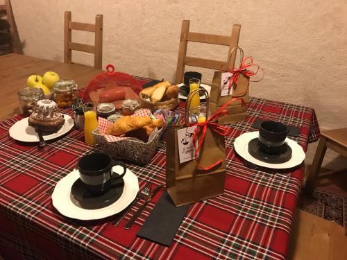 een tafel met een rood tafelkleed en twee borden met eten bij Le Nid de Cigognes in Hengwiller