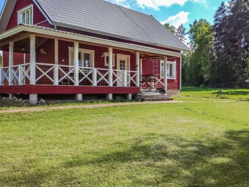 a red house with a grass yard in front of it at Holiday Home Tervaleppä by Interhome in Torvoila