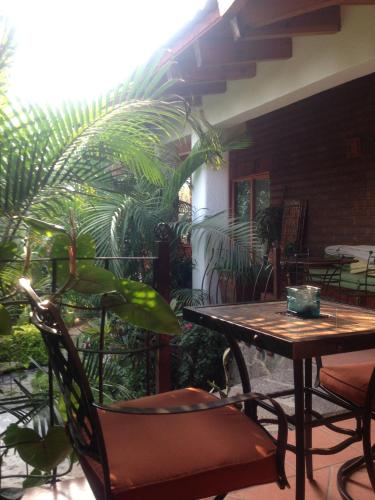 a patio with a table and chairs and plants at Casa d'Lobo Hotel Boutique in Malinalco