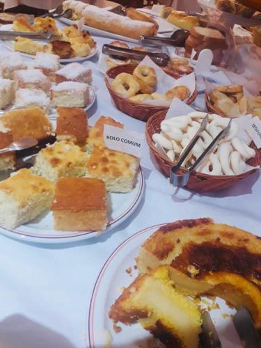 a table full of different types of food on plates at Hotel Plaza Inn Flat Residence in Alfenas