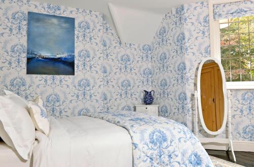 een slaapkamer met blauw en wit behang en een bed bij Little Friston Lodge in Eastbourne