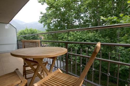 d'une table et de chaises en bois sur un balcon. dans l'établissement Apartaments Rural Montseny, à gualba de Dalt