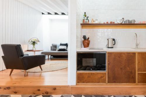 a kitchen and living room with a sink and a chair at Patio São Vicente in Lisbon