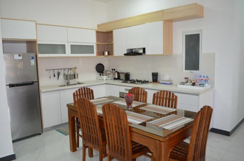 a kitchen with a table and chairs and a refrigerator at Beach Mount Apartment (Blue Ocean Apartment) in Mount Lavinia