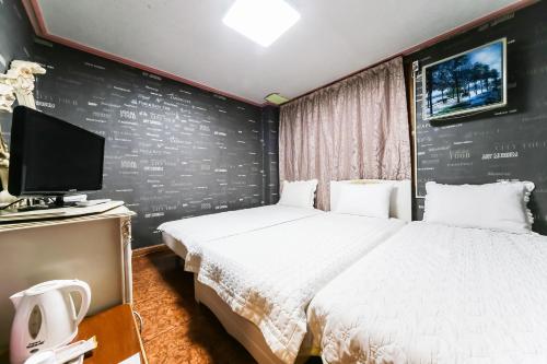 Cette chambre comprend un lit et une télévision. dans l'établissement Mirim Motel, à Gyeongju