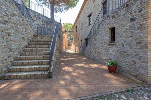 a brick alley with stairs and a potted plant at GH Borgo Pulciano Agriturismo in Montone